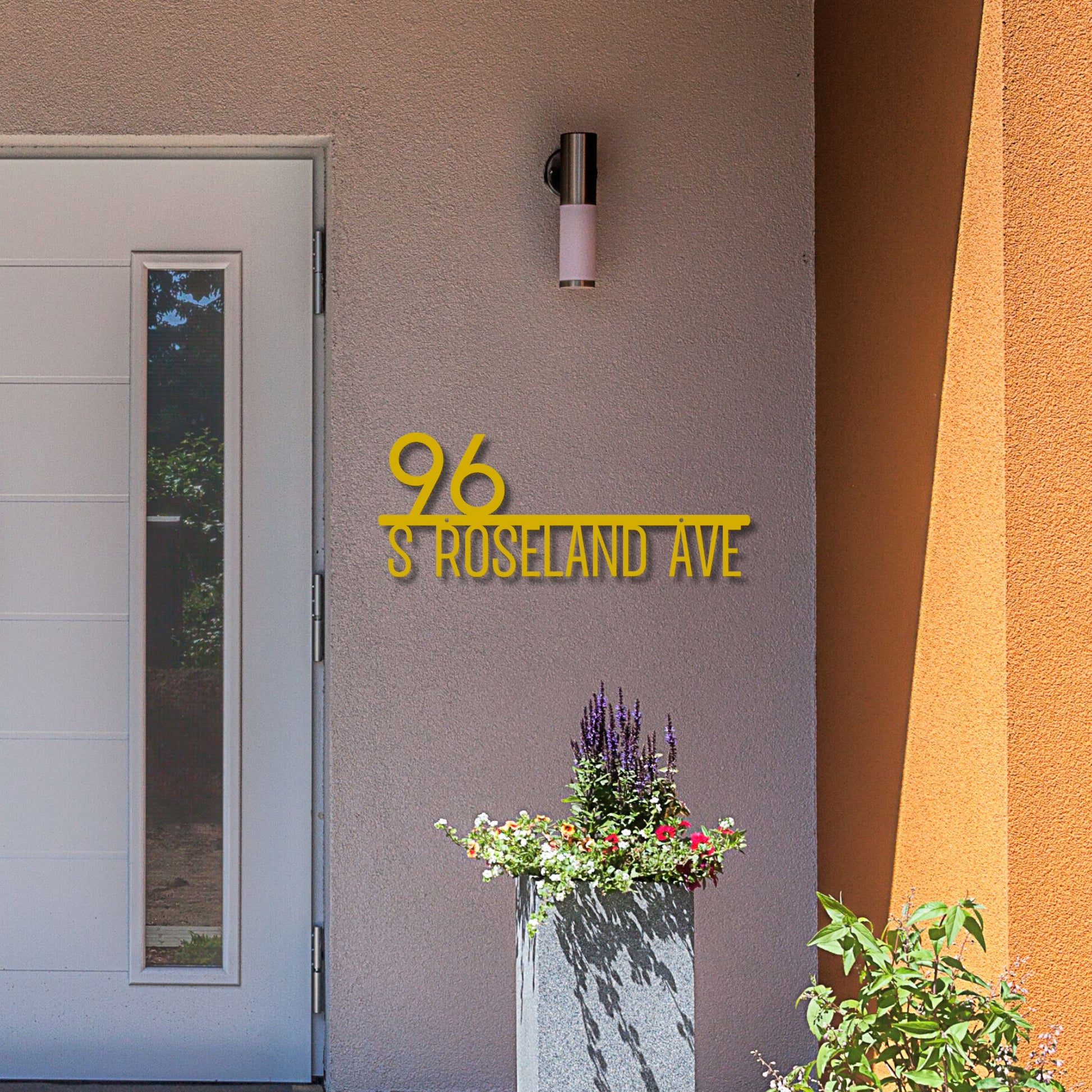 Address sign '96 S Roseland Ave' on a building exterior with a door and plant pot.