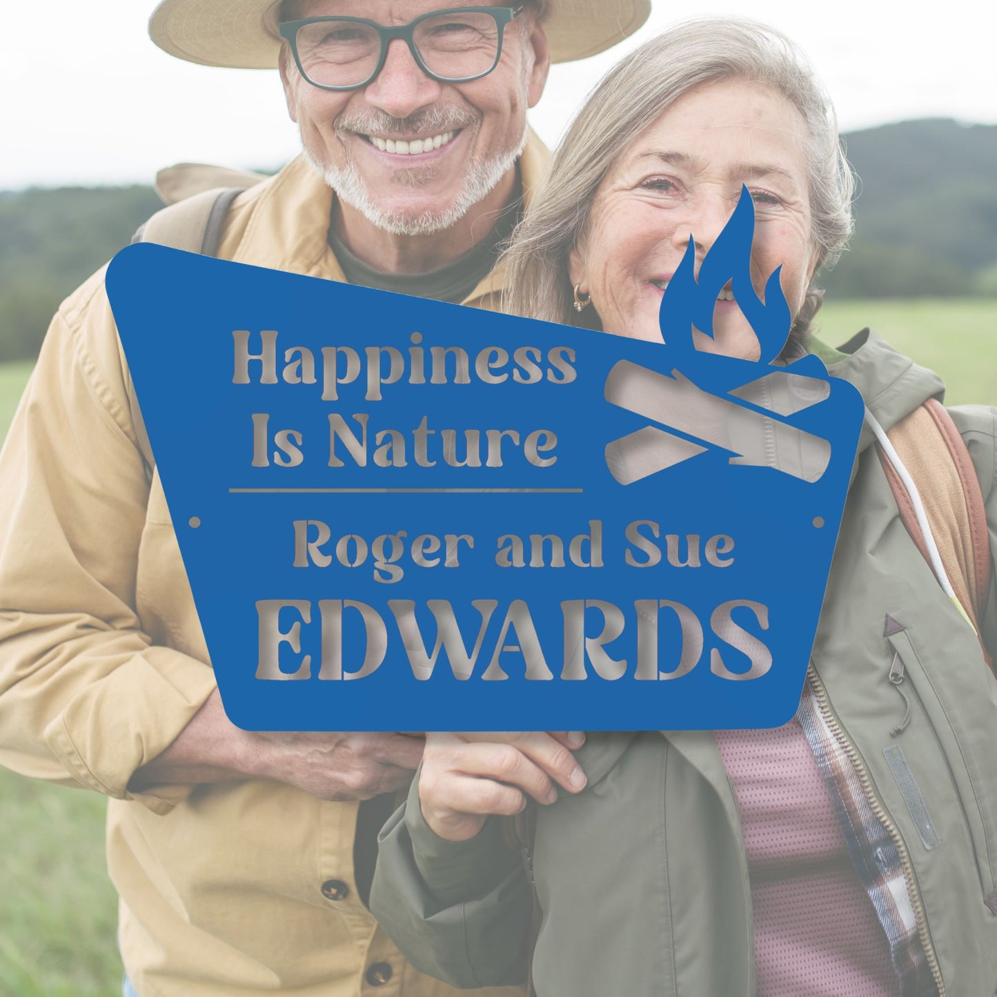 Two people holding a sign with 'Happiness Is Nature' and 'Roger and Sue Edwards' text, standing outdoors.
