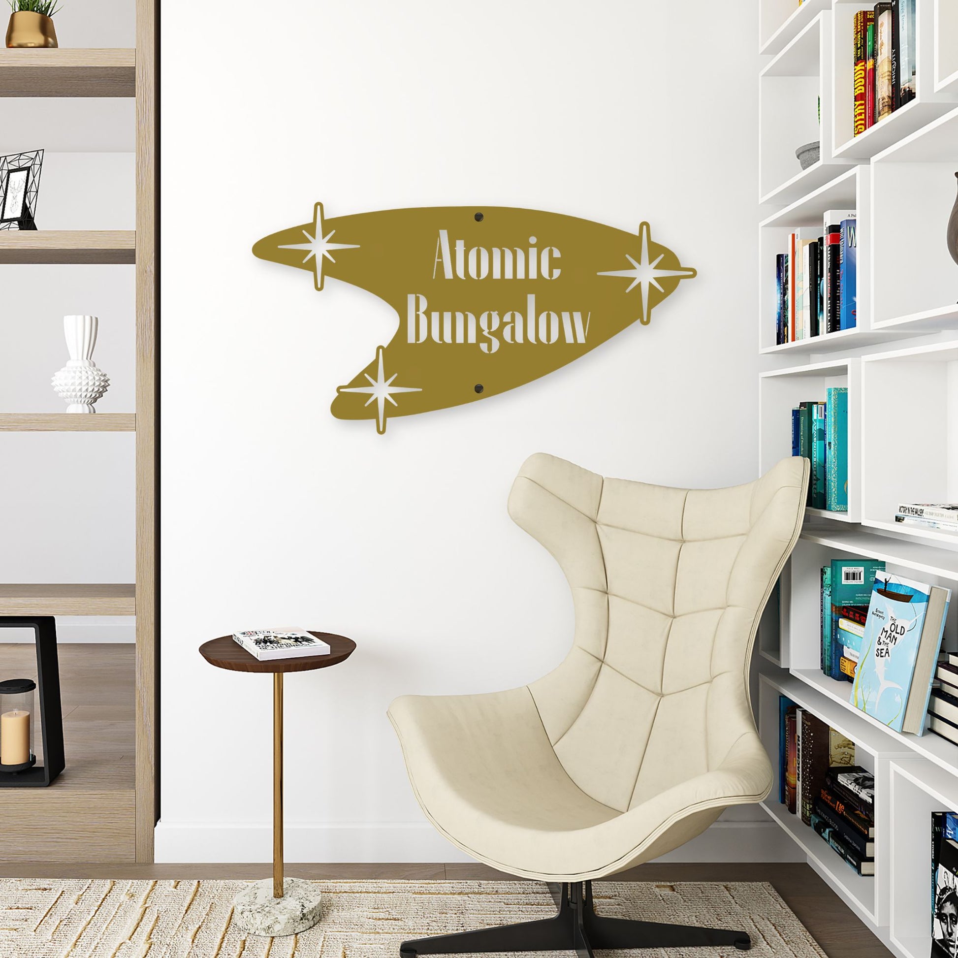 Beige chair in a room with a 'Atomic Bungalow' wall art piece and bookshelves.