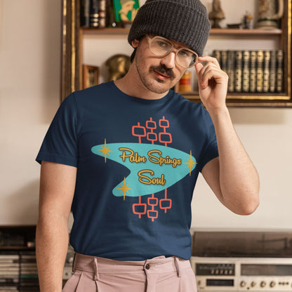 Person wearing a navy blue t-shirt with 'Palm Springs Soul' design in a room with vintage decor.