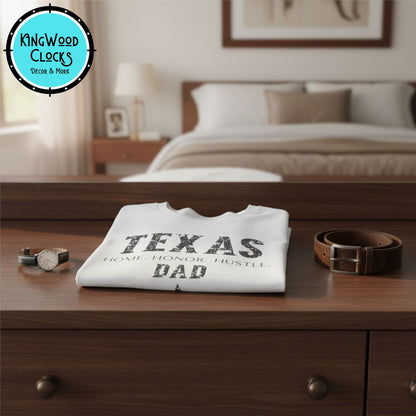 Folded t-shirt with 'TEXAS DAD' text on a wooden dresser in a bedroom setting.
