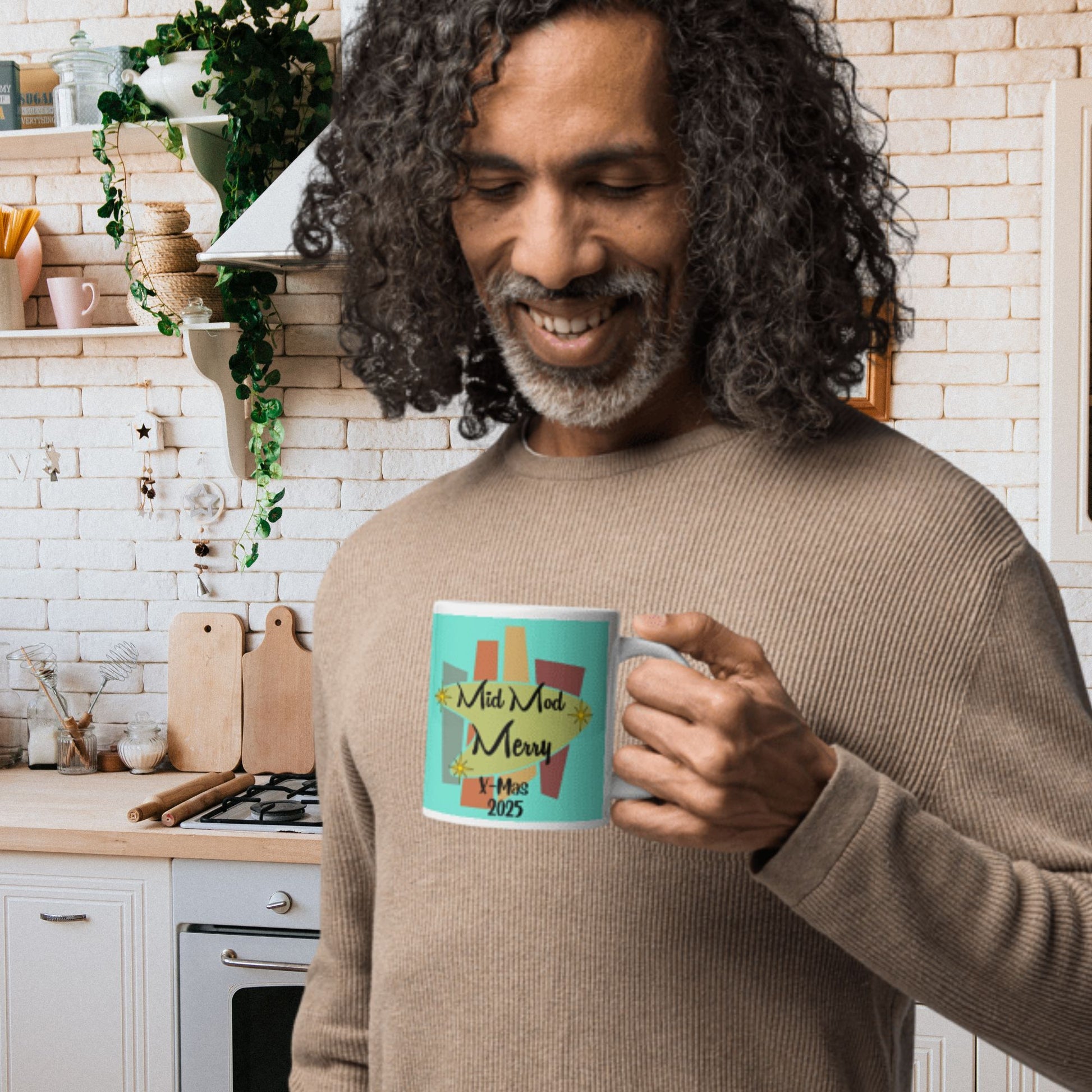 Man holding a mug with a festive design in a kitchen
