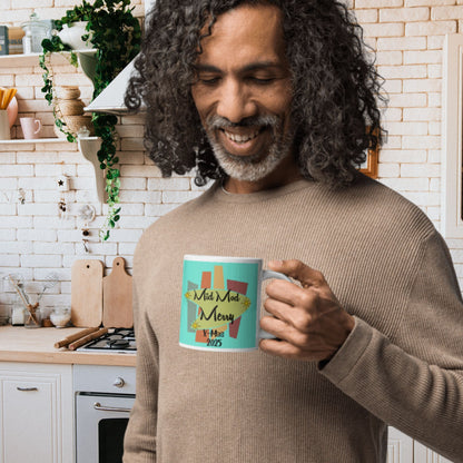 Man holding a mug with a festive design in a kitchen