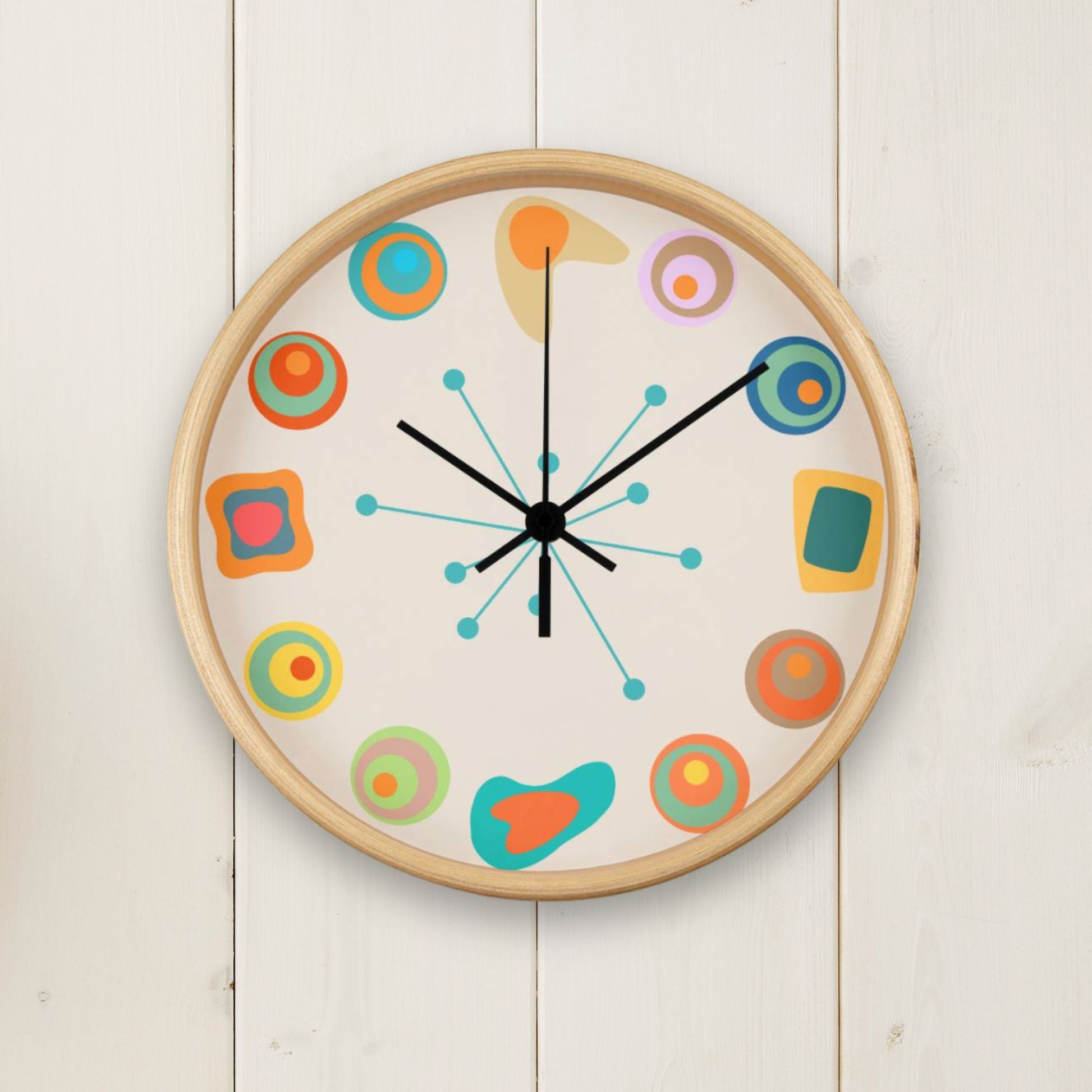 Colorful wall clock with abstract designs on a white wooden background