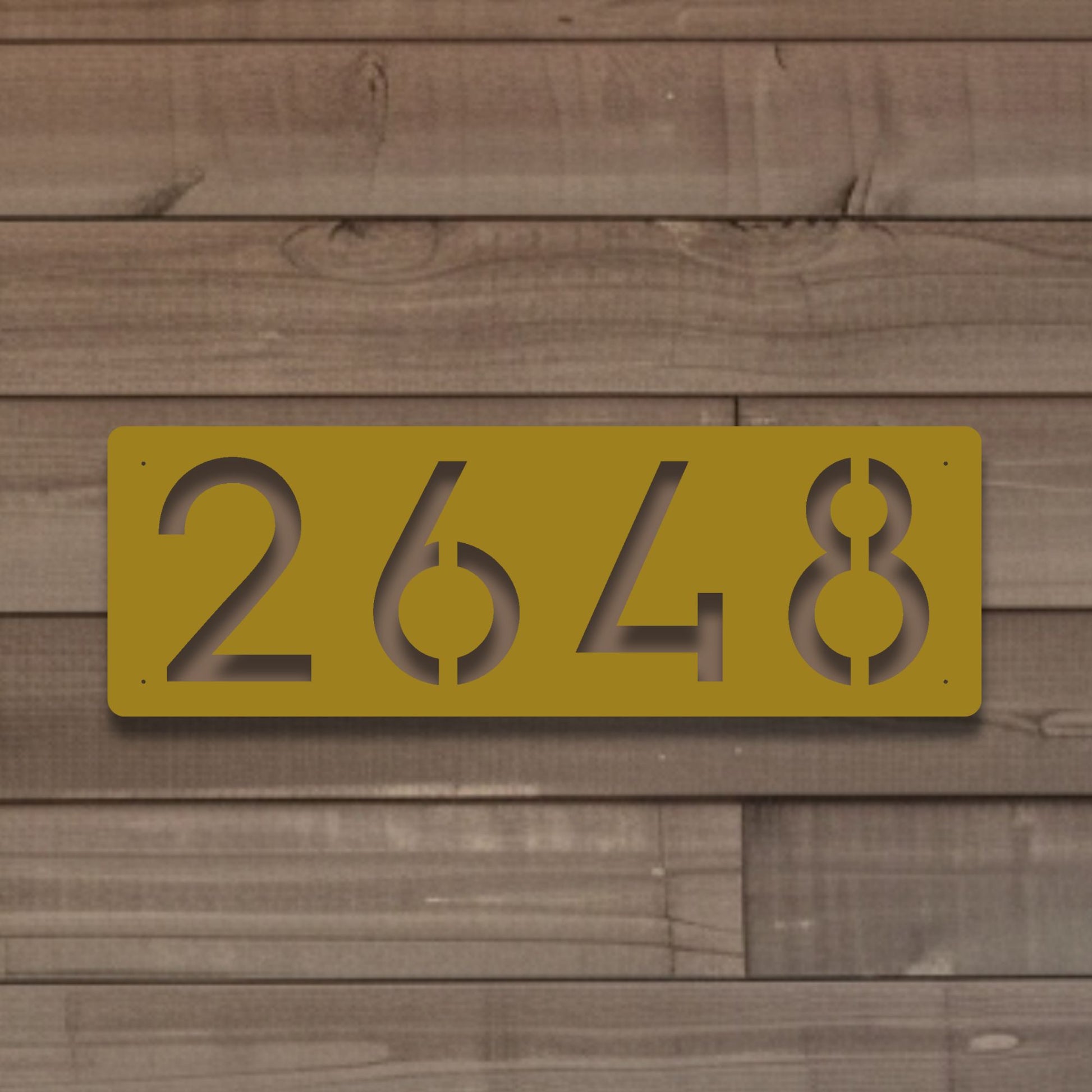 Horizontal Number Address Sign, Closed Style shown in gold against worn wood siding on home