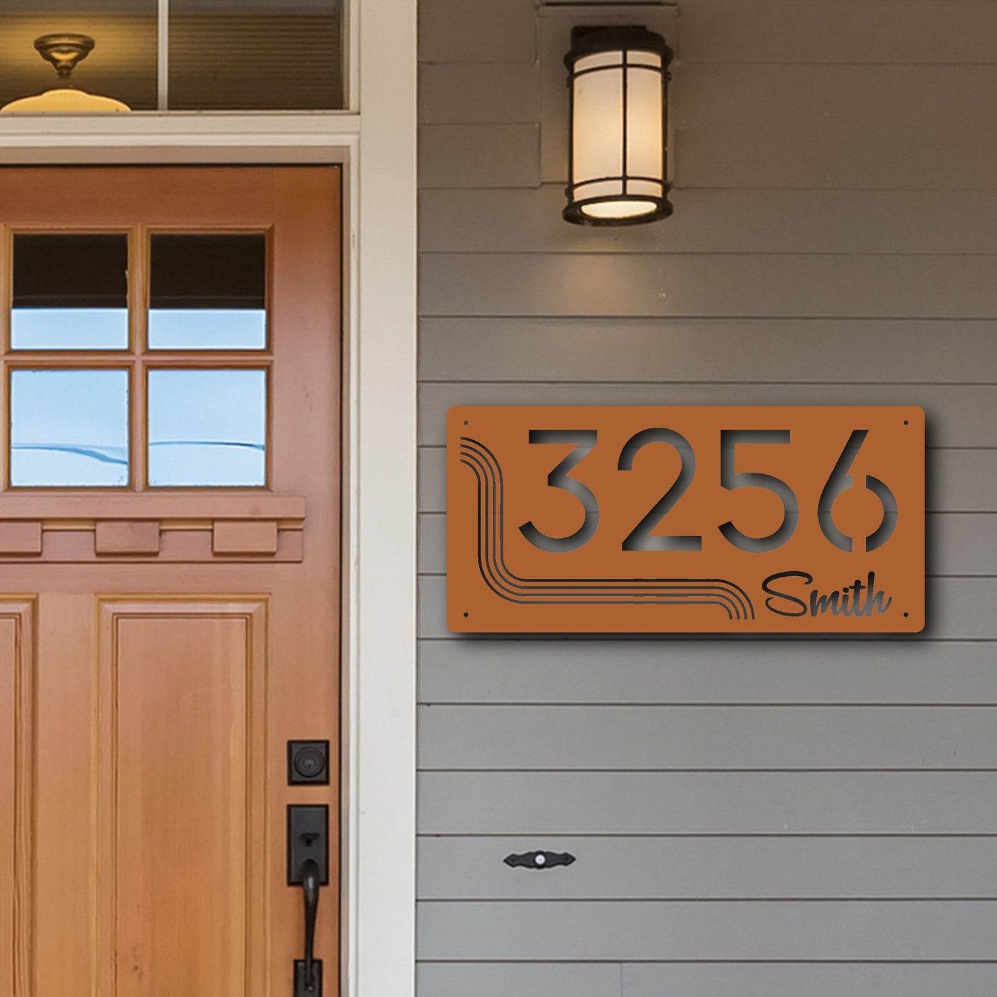 House number sign '3256 Smith' on a gray wall next to a wooden door.