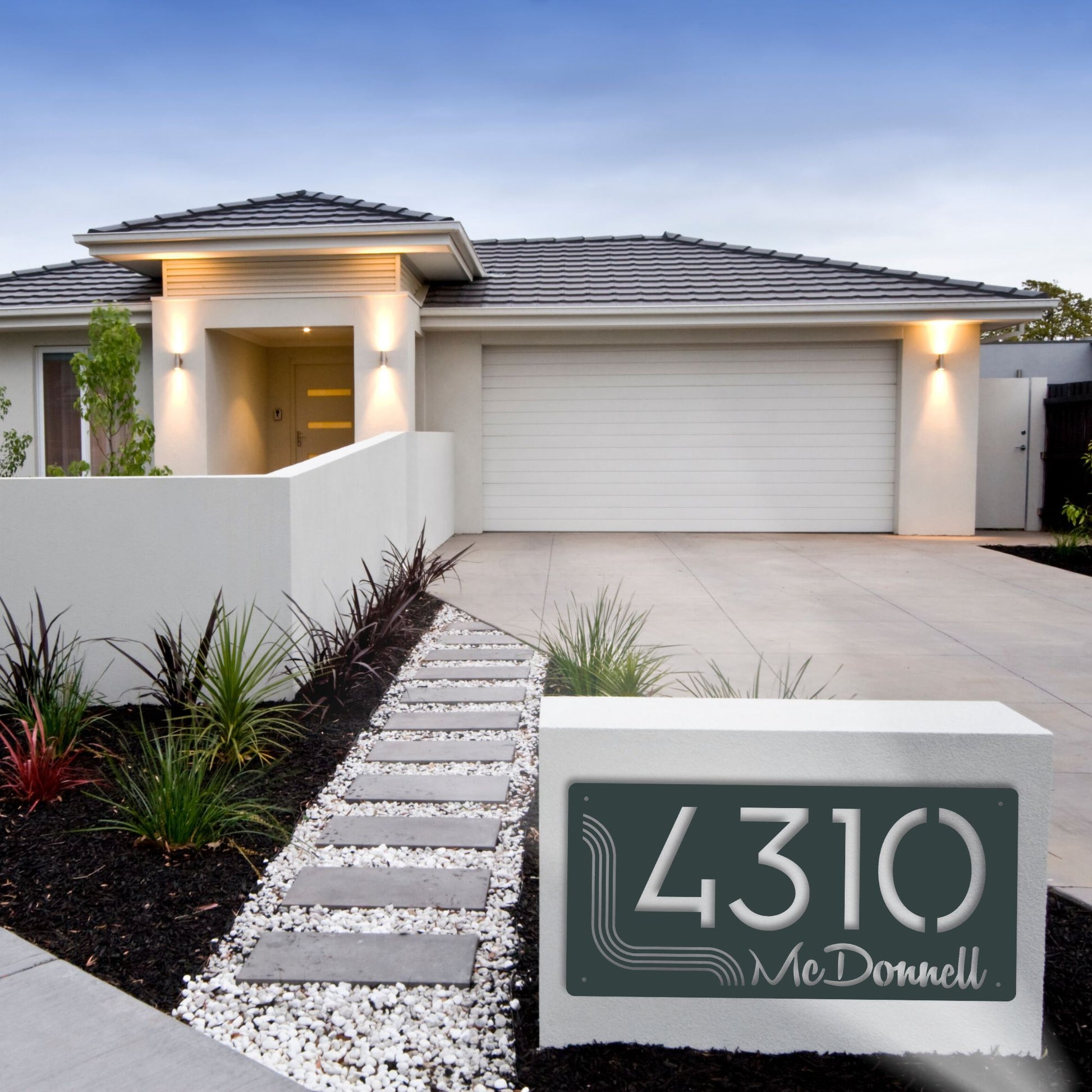 Modern house with a driveway and decorative house number sign.