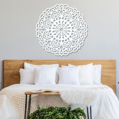 Decorative wall art above a bed with white bedding and wooden headboard.