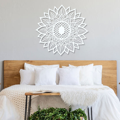 Decorative mandala wall art above a bed with white bedding and wooden headboard.