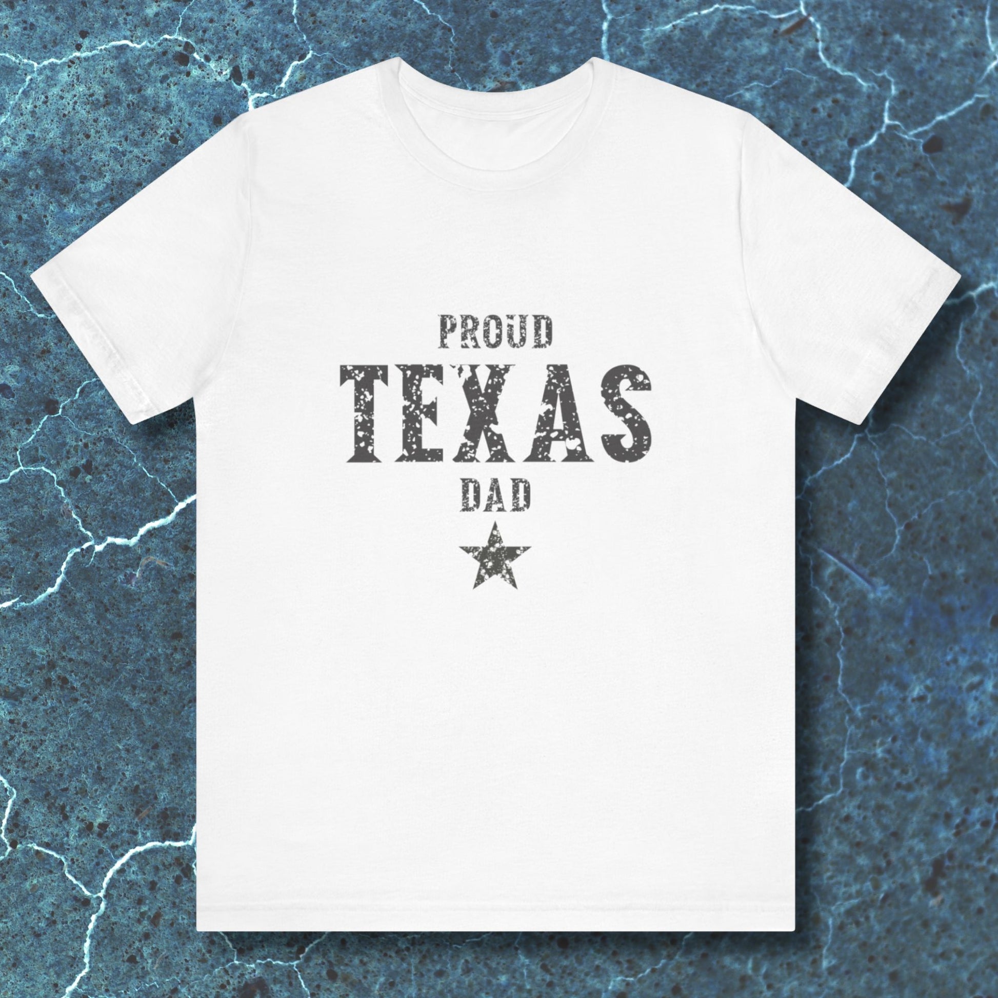 White t-shirt with 'Proud Texas Dad' text on a textured blue background