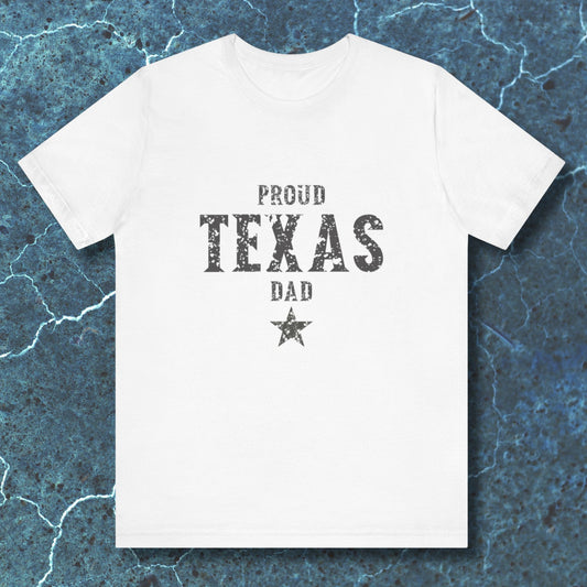 White t-shirt with 'Proud Texas Dad' text on a textured blue background