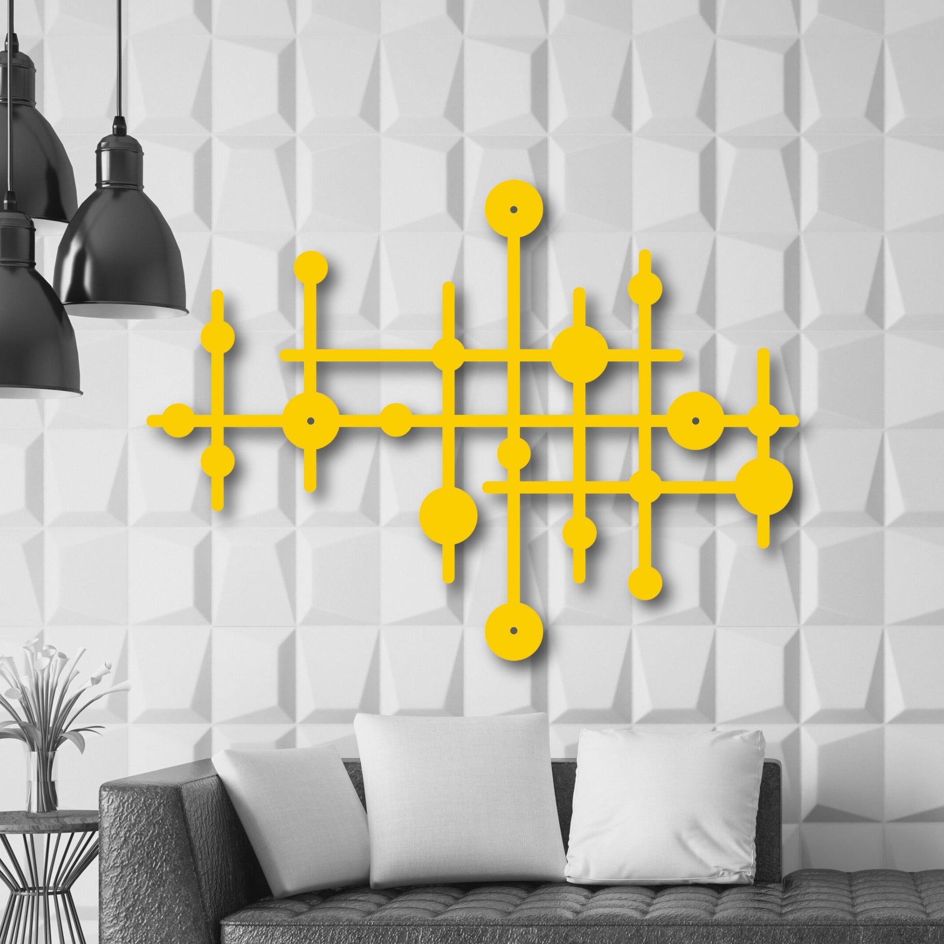 Yellow geometric wall art on a textured white wall with black pendant lights and a gray sofa.