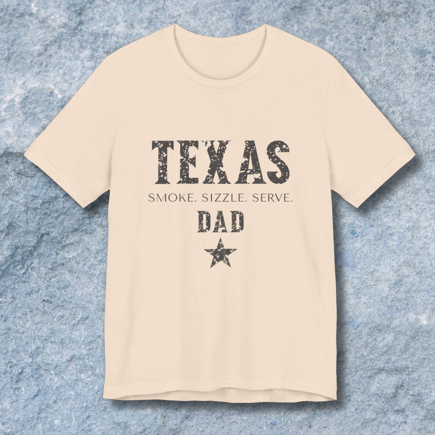 Beige t-shirt with 'Texas Dad' text on a textured blue background