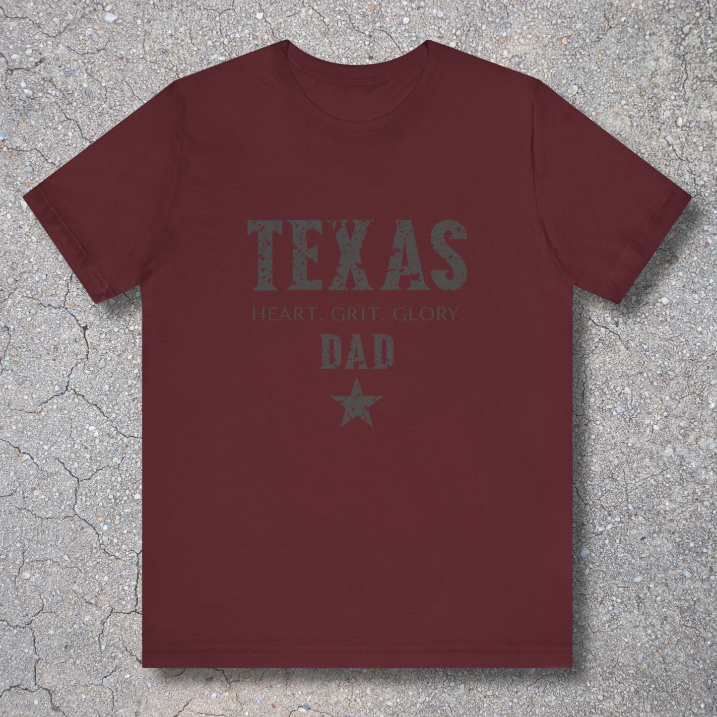Maroon t-shirt with 'TEXAS HEART Grit Glory DAD' text on a textured surface