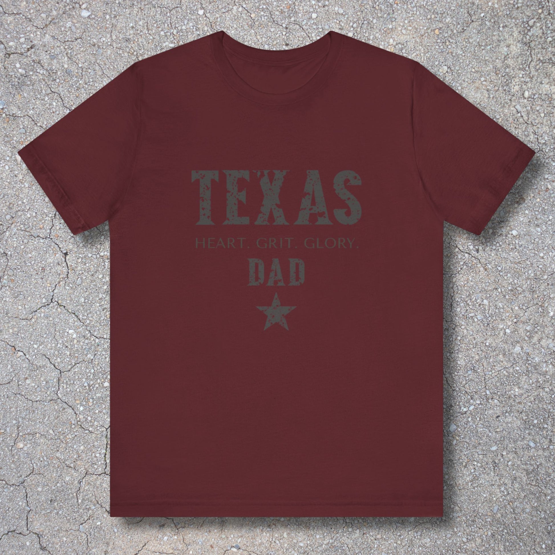 Maroon t-shirt with 'TEXAS HEART Grit Glory DAD' text on a textured surface