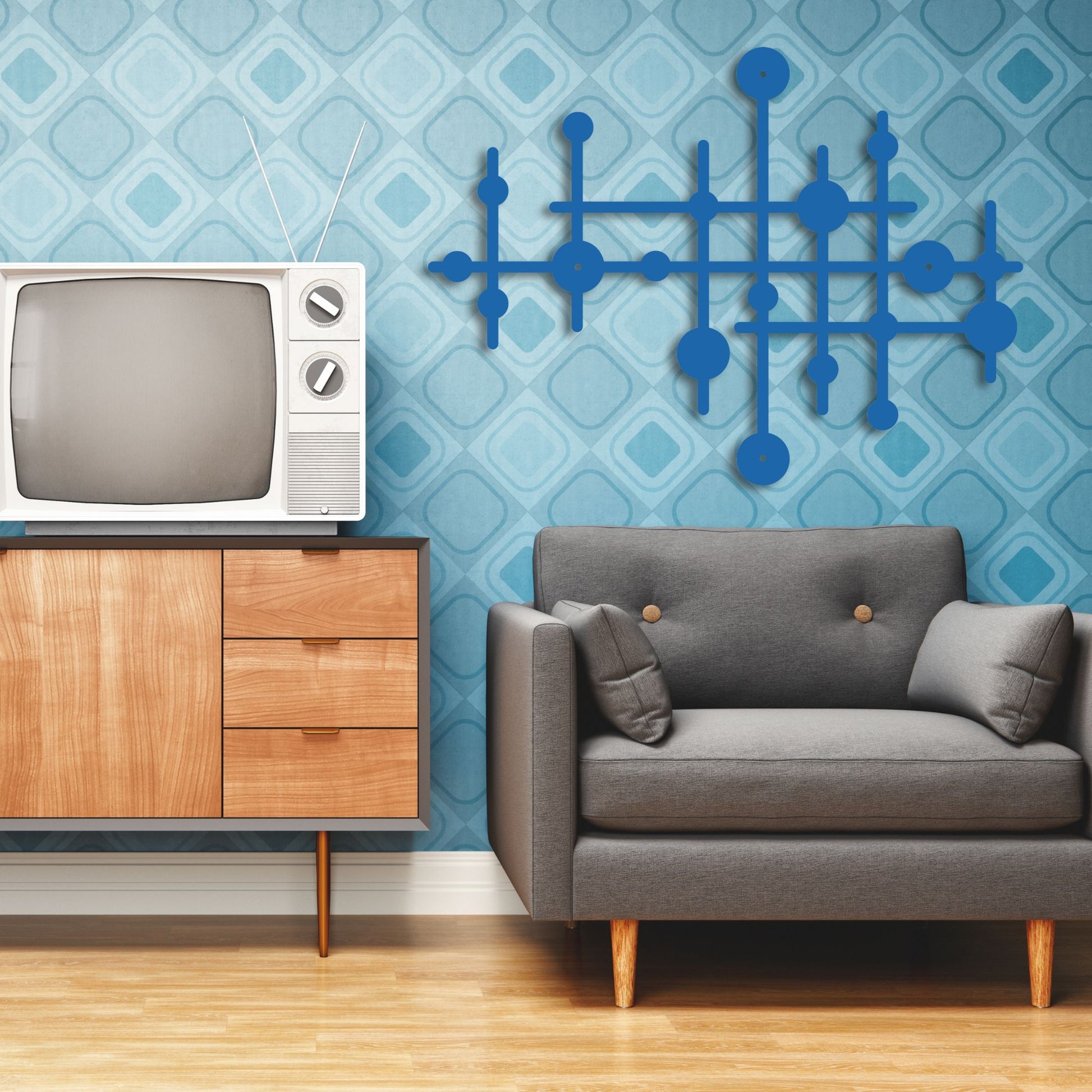 Living room with vintage TV, wooden cabinet, and gray sofa against a blue patterned wall.