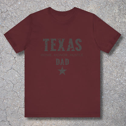 Maroon t-shirt with 'TEXAS HOME HONOR HUSTLE DAD' text on a textured surface