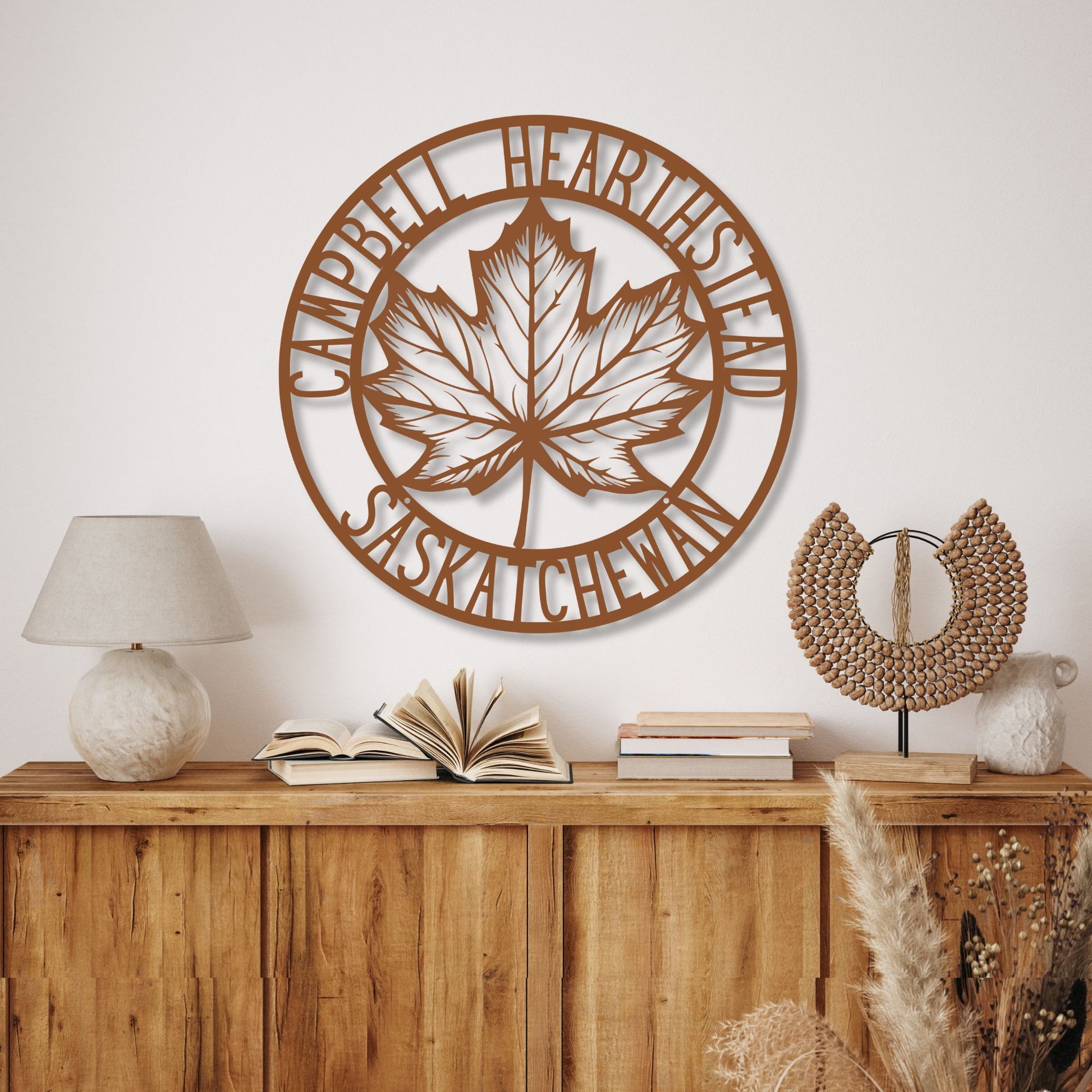 Decorative wall art with a leaf design and text on a wall above a wooden console table.