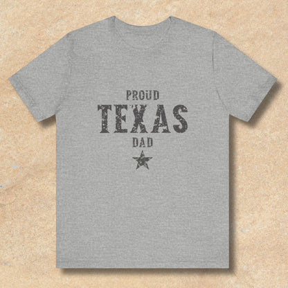 Gray t-shirt with 'Proud Texas Dad' text on a beige background