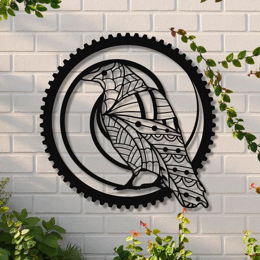 Decorative metal wall art of a bird inside a gear on a white brick wall with greenery.