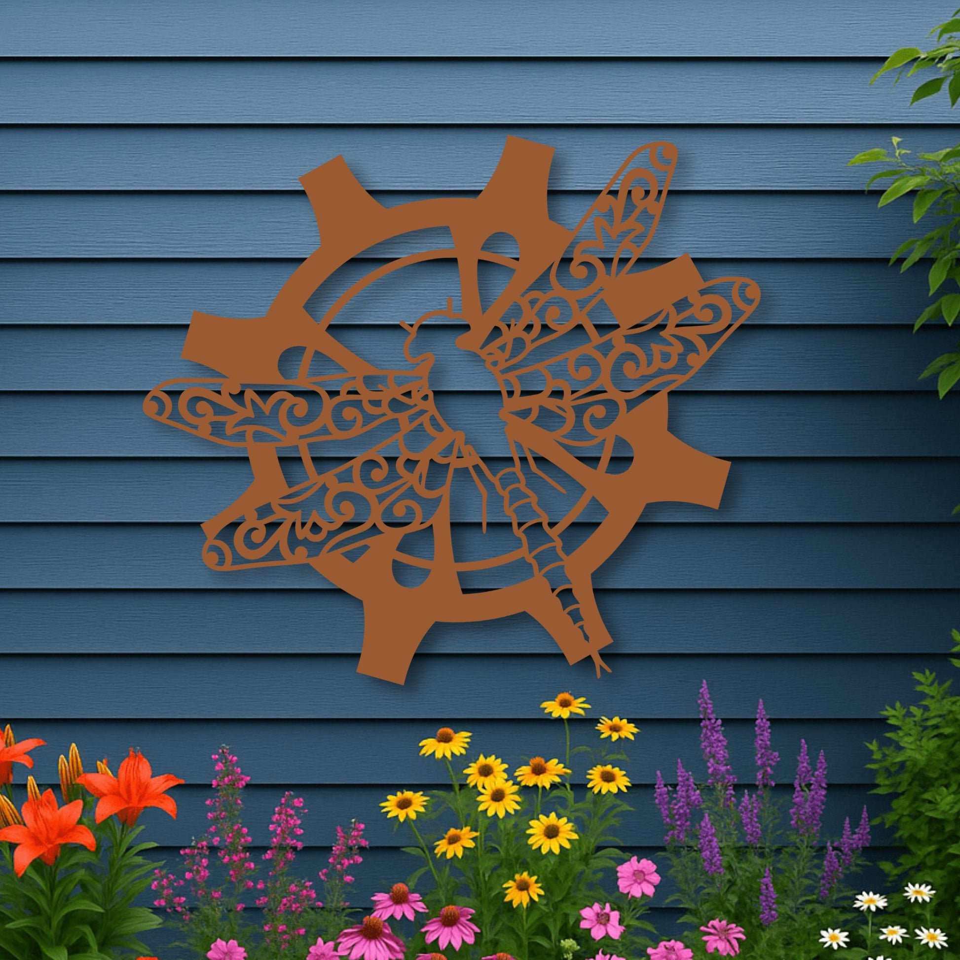 Decorative metal wall art of a deer and antlers on a blue wooden wall with flowers in the foreground.