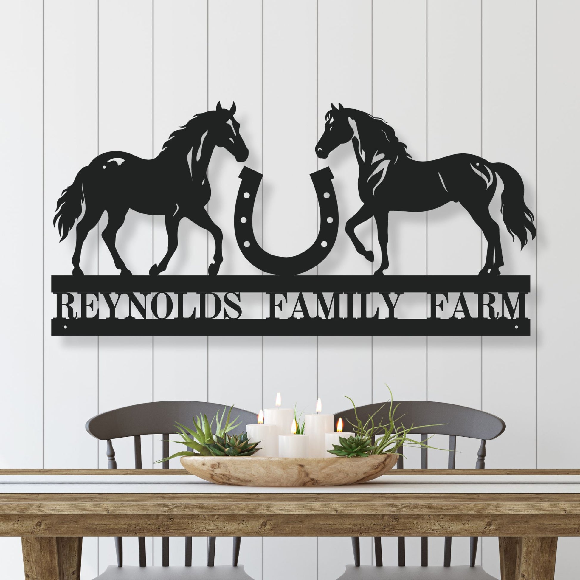 Decorative metal wall art with horses and a horseshoe, featuring 'Reynolds Family Farm' text, on a white wooden panel background.