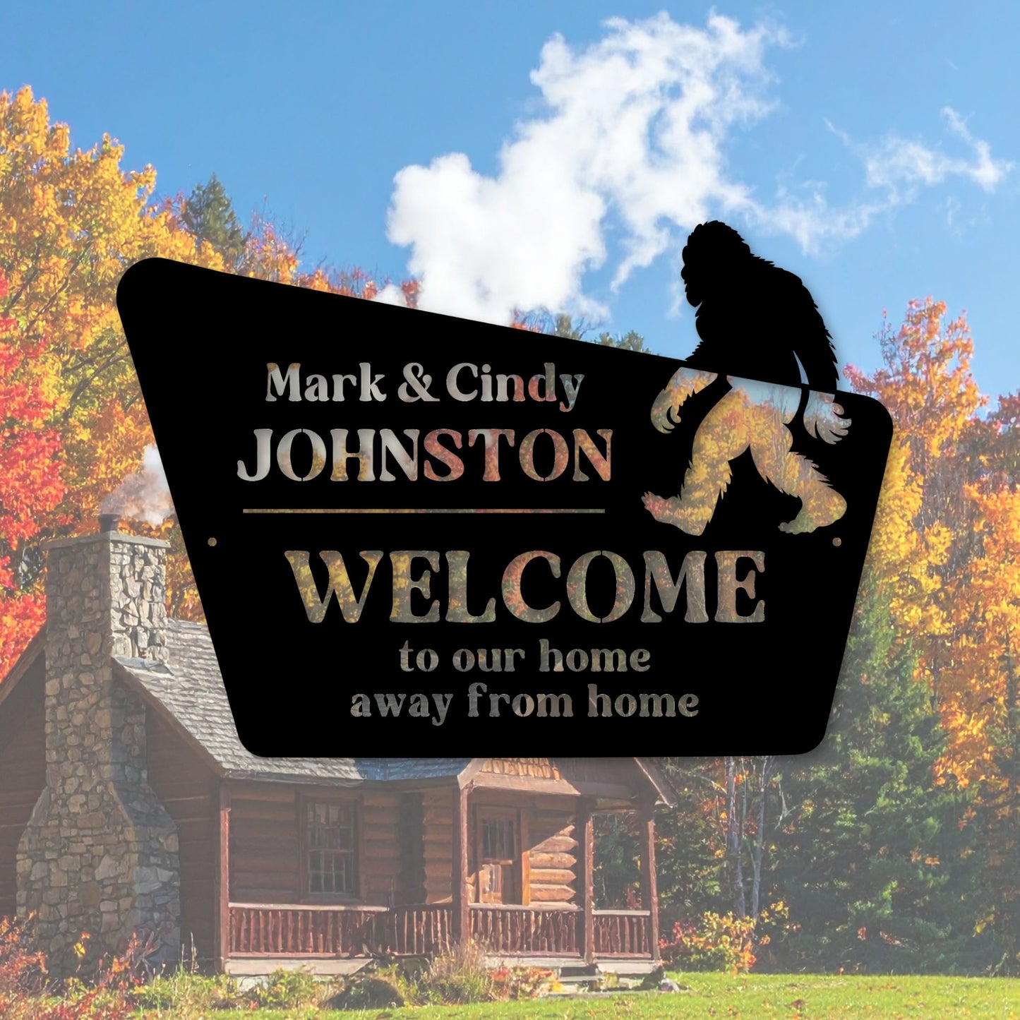 Bigfoot-themed welcome sign with personalized names in front of a log cabin during autumn.