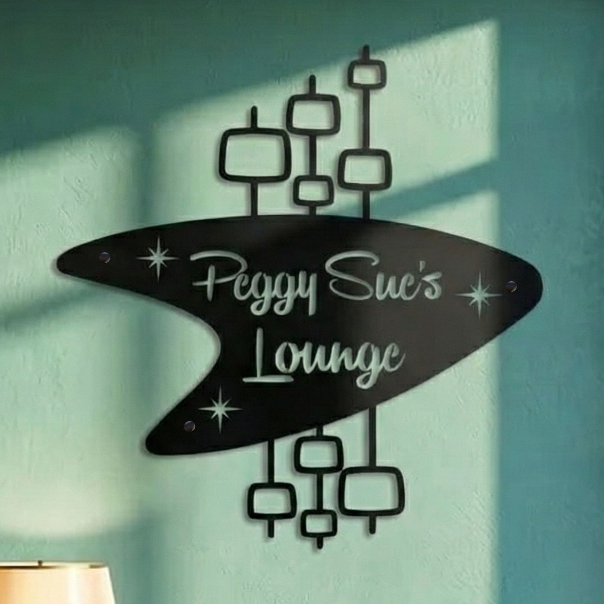 Decorative wall art with 'Peggy Sue's Lounge' text on a teal wall.