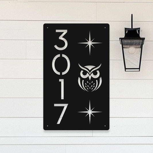 Black metal sign with white owl design and numbers '3017' on a light wooden background
