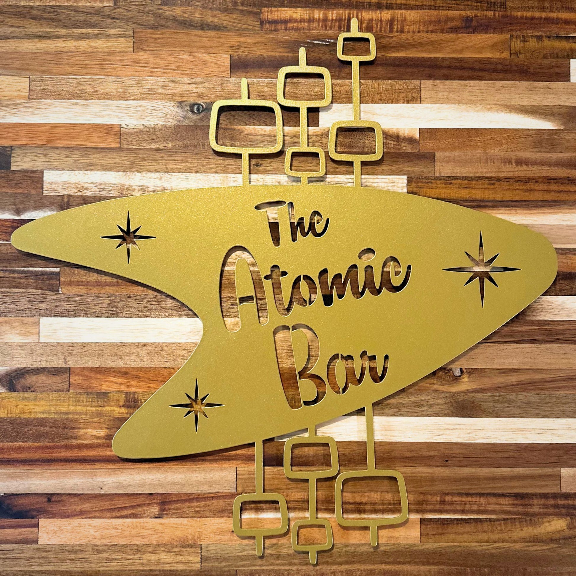 gold boomerang metal wall art with the atomic bar die cut into metal