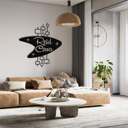 Personalized Mid Century Modern Name Sign shown in black hanging over living room couch