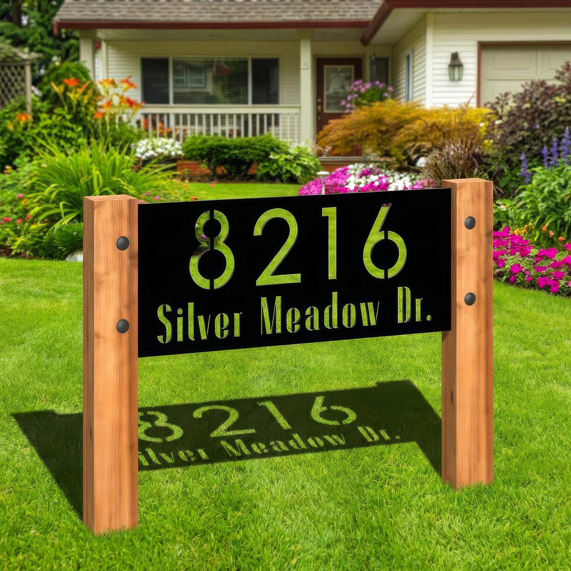 House number sign with '8216 Silver Meadow Dr.' on a grassy lawn in front of a house.