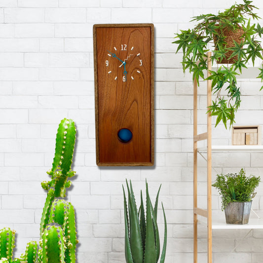 KingWood Pendulum Wall Clock In Cedar & Blue on brick wall